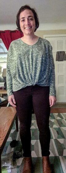 The same woman wears a gray blouse gathered at the waist and black leggings.